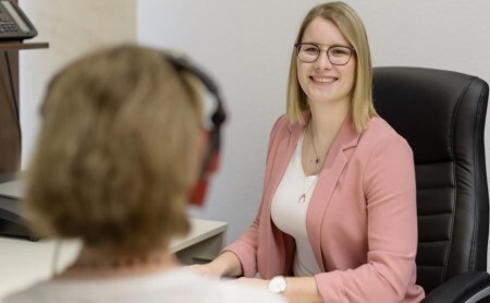 Frau mit Brille im Beratungsgespräch im modernen Büro, professionelle Finanzberatung